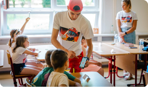 Tým kocoura preventisty ukazující dětem aplikaci na mobilu ve třídě