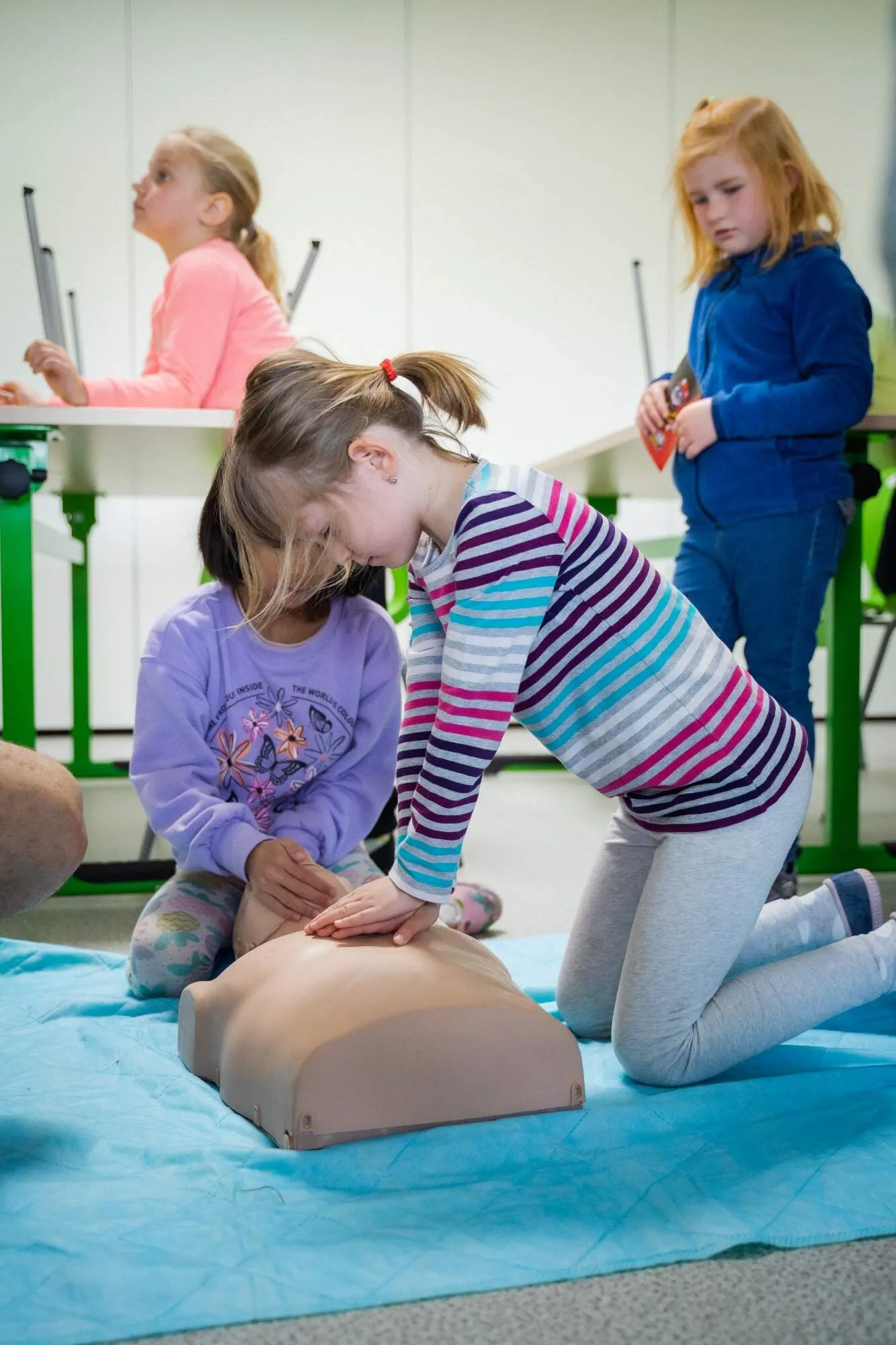 Dítě dělající CPR cvičné figuríně ZŠ Plaňany